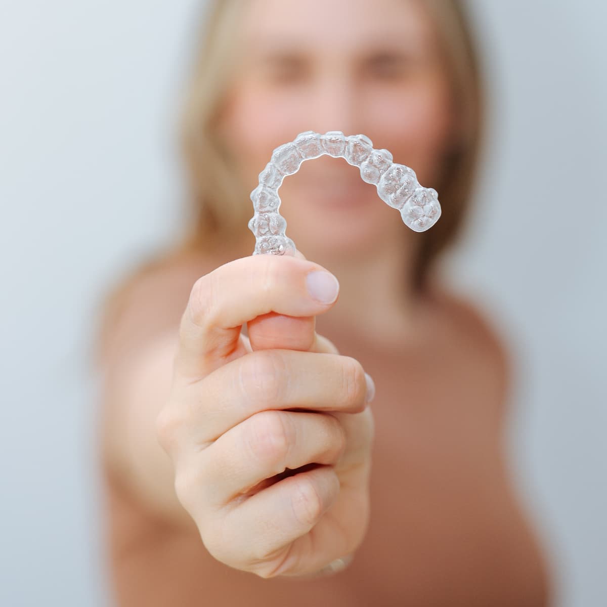 Alineador dental transparente sostenido en primer plano